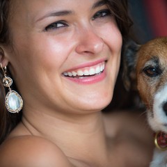 Kassandra modeling Dana Kellin Earrings holding Olive the dog.
